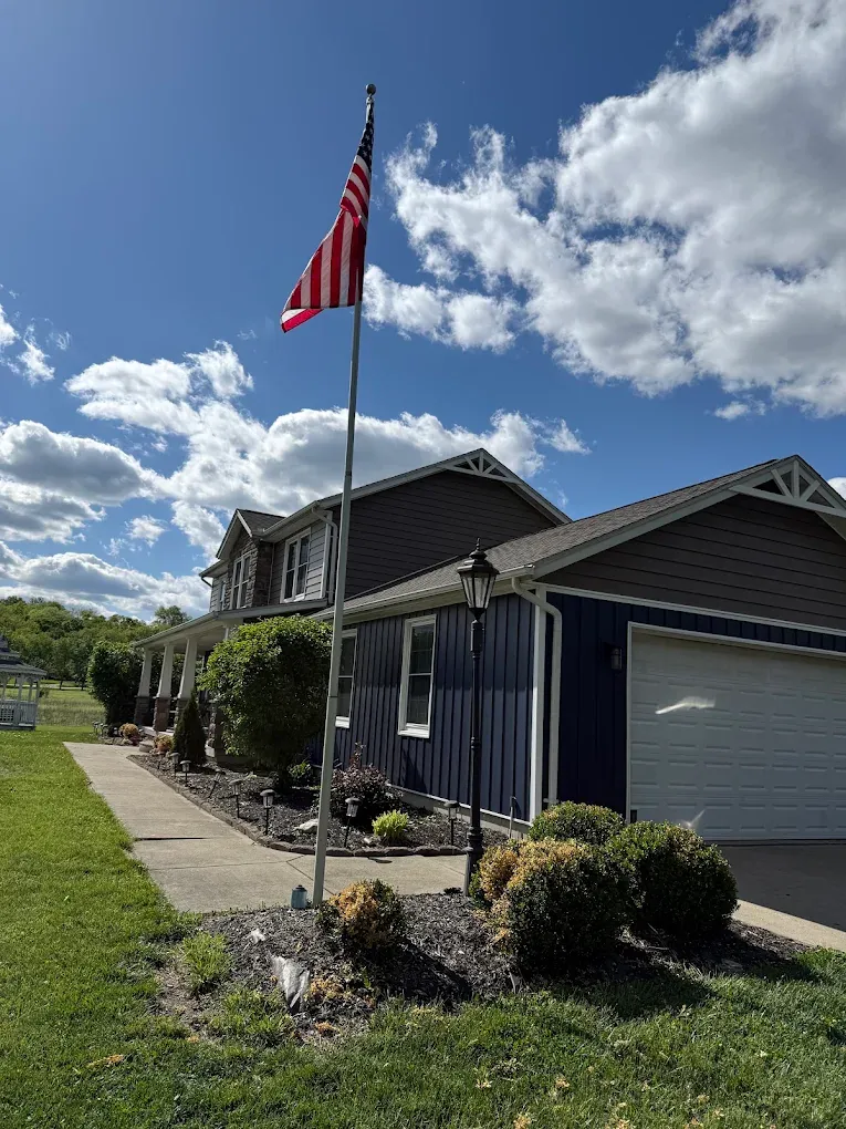 Navy board-and-batten siding on a farmhouse-style home with wrap-around porch in Batavia, Ohio