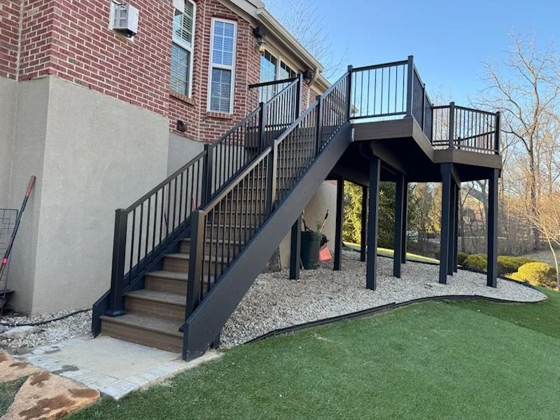 Elevated second-story deck with black steel staircase and railing on a brick home in Loveland, Ohio