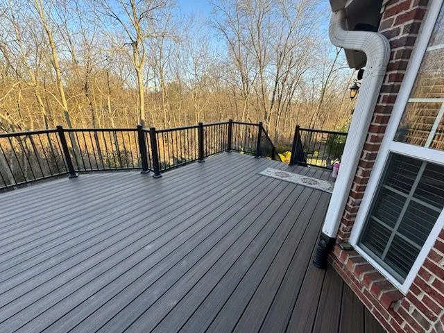 Large gray composite deck with black aluminum railing on a brick home in Batavia, Ohio by Abrams Restoration
