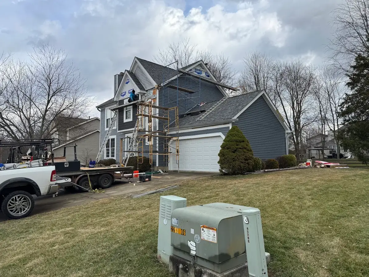Two-story home mid-siding replacement with blue vinyl siding and scaffolding in New Richmond, Ohio