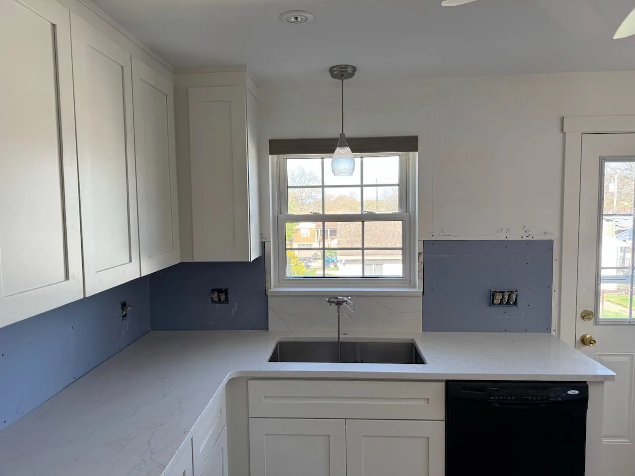 New white shaker cabinets with quartz countertops and peninsula in a remodeled kitchen in Batavia, Ohio