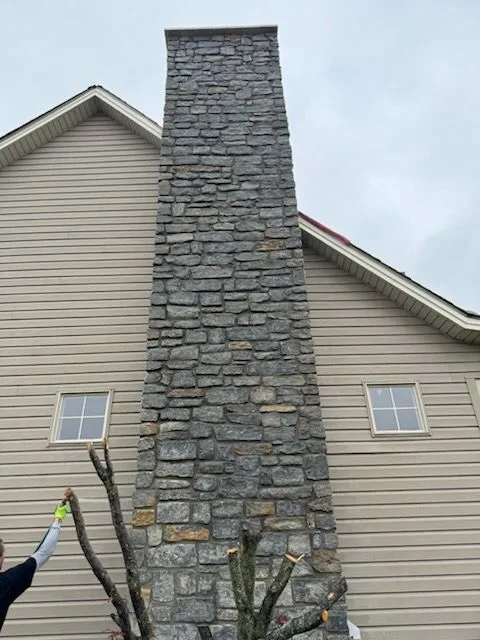 Full-height stone chimney rebuilt and restored on a two-story home in Milford, Ohio by Abrams Restoration