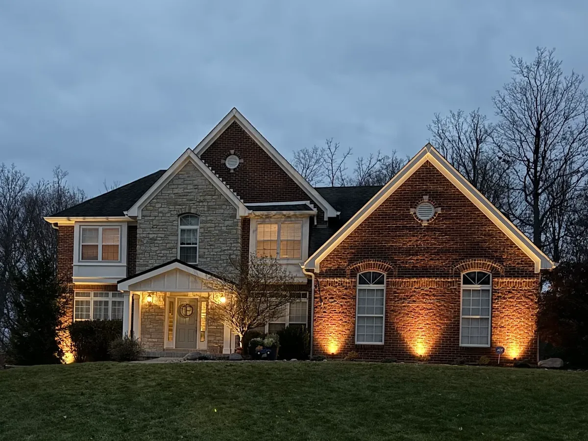 Architectural landscape and uplighting on a brick and stone home at dusk in Cincinnati, Ohio