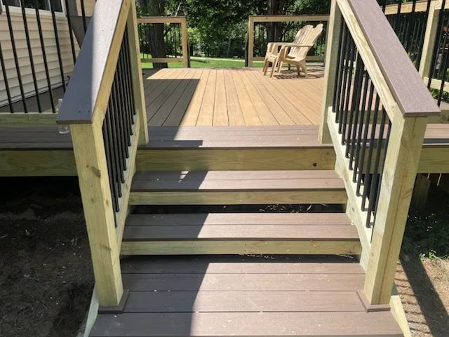 Two-tone composite deck with contrasting picture-frame border and stairs to the yard in Milford, Ohio